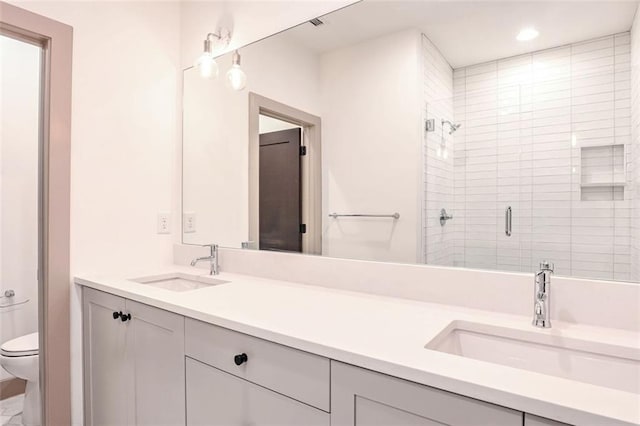 bathroom with toilet, an enclosed shower, and vanity