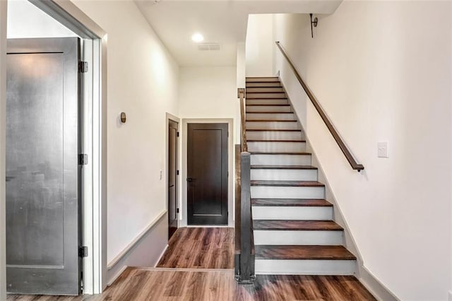 staircase with hardwood / wood-style flooring