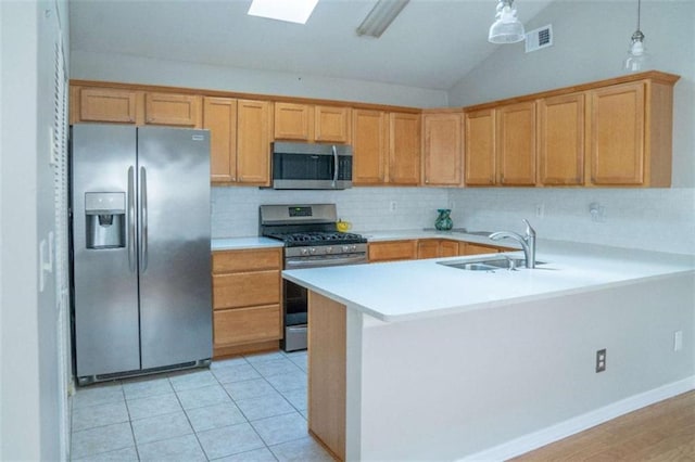 kitchen with sink, appliances with stainless steel finishes, backsplash, decorative light fixtures, and kitchen peninsula