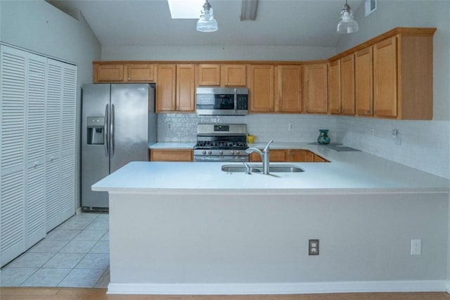 kitchen featuring lofted ceiling with skylight, decorative light fixtures, light tile patterned floors, stainless steel appliances, and backsplash