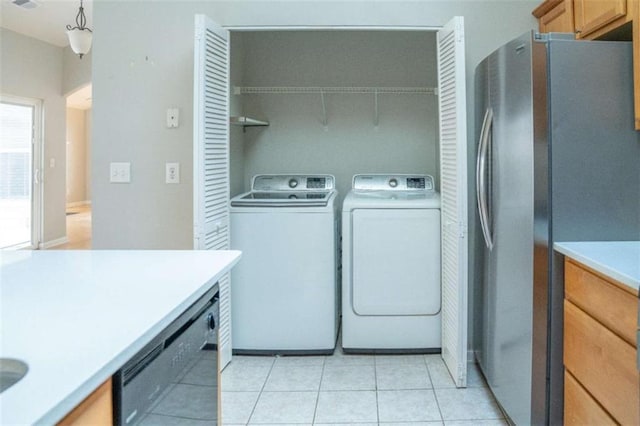 laundry room featuring washer and dryer and light tile patterned floors