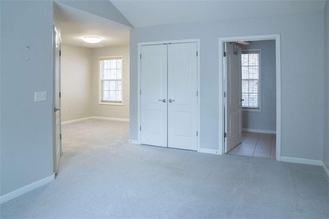 unfurnished bedroom featuring light carpet and a closet