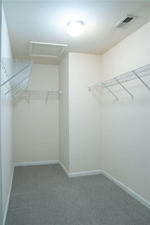 walk in closet featuring dark carpet