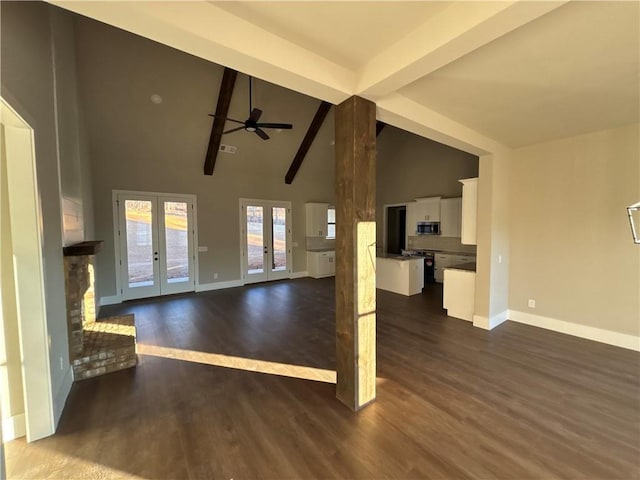 unfurnished living room with beam ceiling, ceiling fan, french doors, dark wood-type flooring, and high vaulted ceiling