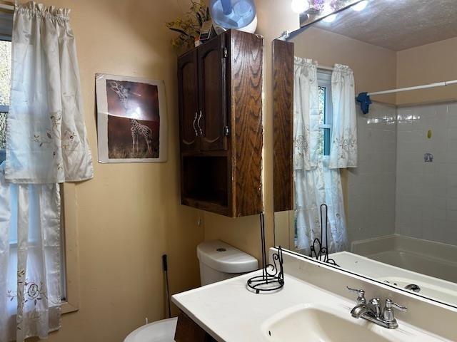 bathroom featuring vanity, a textured ceiling, and toilet