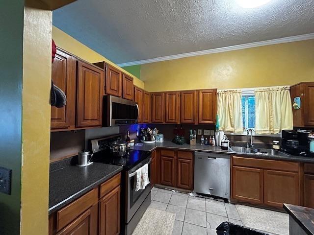 kitchen featuring crown molding, sink, a textured ceiling, and appliances with stainless steel finishes