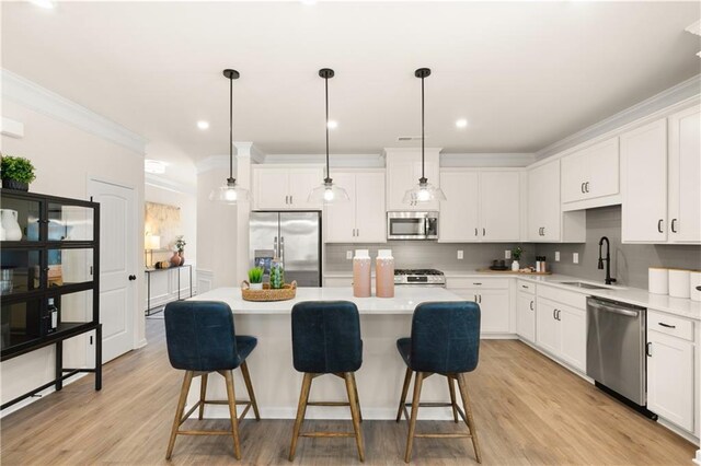 kitchen featuring a kitchen island, light wood-type flooring, white cabinets, and stainless steel appliances