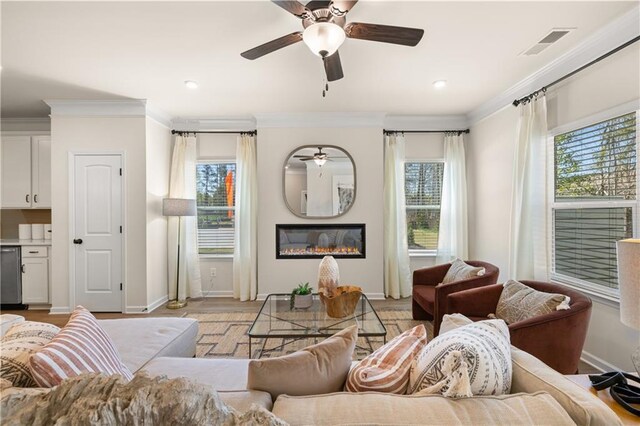 living room with ceiling fan, light wood-type flooring, and crown molding