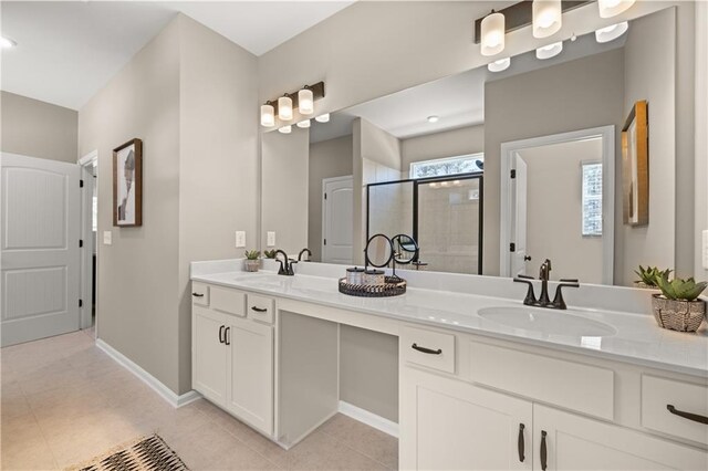 bathroom with a shower with door, vanity, and tile patterned flooring