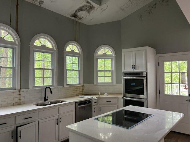 730 Redlion Run, Alpharetta, GA 30022 - kitchen with black appliances, a sink, a center island, tasteful backsplash, and white cabinetry