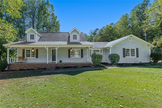 cape cod house featuring a front yard and covered porch