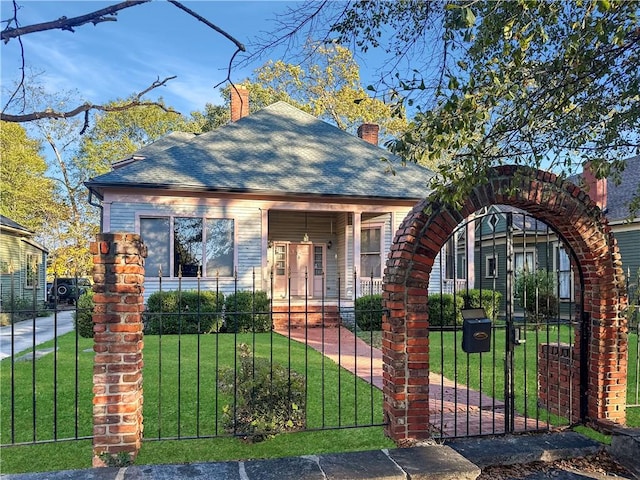 bungalow-style home with covered porch and a front yard