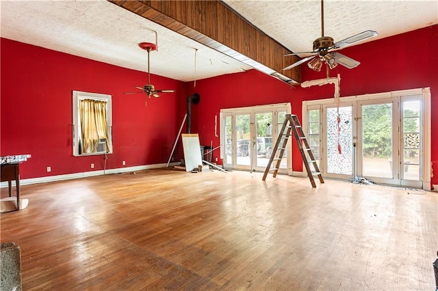 unfurnished living room with hardwood / wood-style floors, a textured ceiling, and french doors