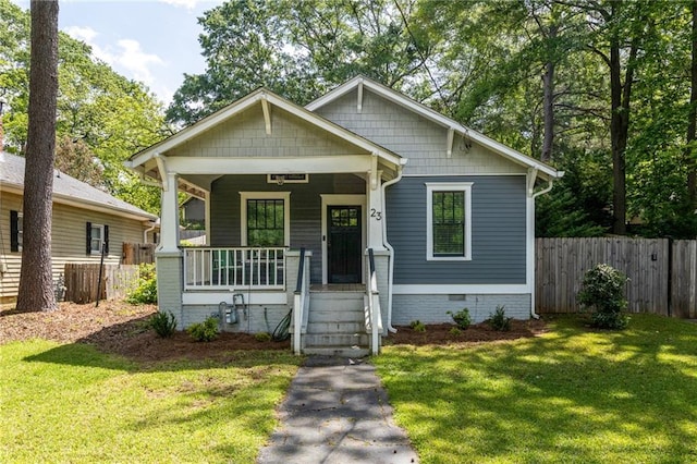 bungalow with a porch, fence, a front lawn, and crawl space