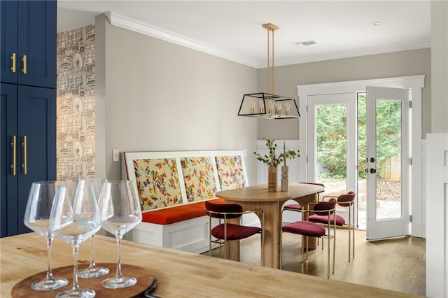 dining area with french doors, visible vents, wood finished floors, and ornamental molding