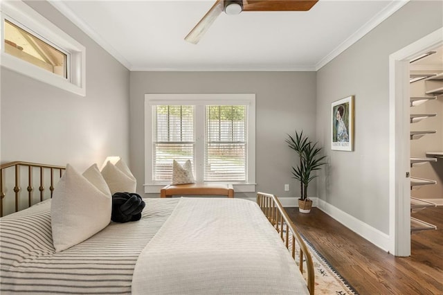 bedroom with crown molding, baseboards, a ceiling fan, and wood finished floors