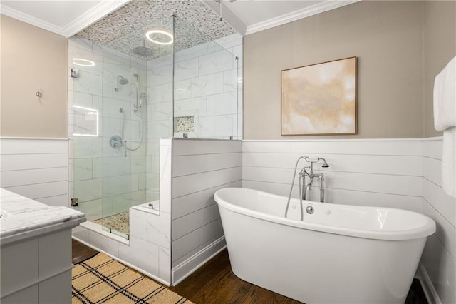 full bath featuring wood finished floors, crown molding, a shower stall, wainscoting, and a freestanding bath