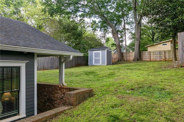 view of yard with a fenced backyard, an outdoor structure, and a storage shed