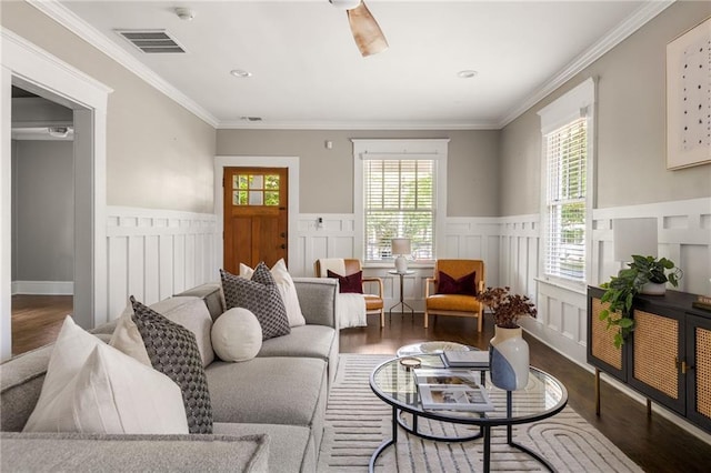 living area featuring wainscoting, visible vents, and wood finished floors