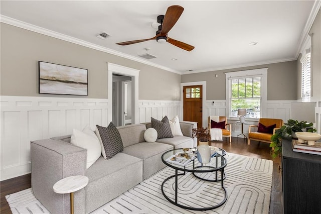 living area featuring wainscoting, a ceiling fan, visible vents, and wood finished floors