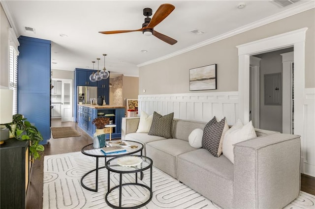 living area with ceiling fan, visible vents, and wood finished floors