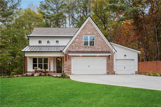 view of front of home featuring covered porch, a garage, and a front yard