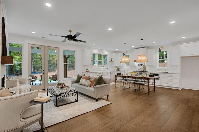 living room featuring dark wood-type flooring, sink, french doors, and ceiling fan