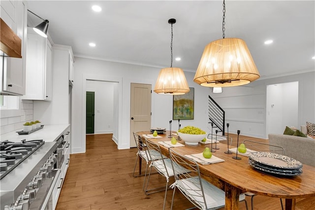 kitchen featuring double oven range, crown molding, dark hardwood / wood-style flooring, decorative backsplash, and white cabinets