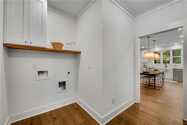 laundry area featuring hookup for an electric dryer, cabinets, ornamental molding, washer hookup, and light hardwood / wood-style flooring