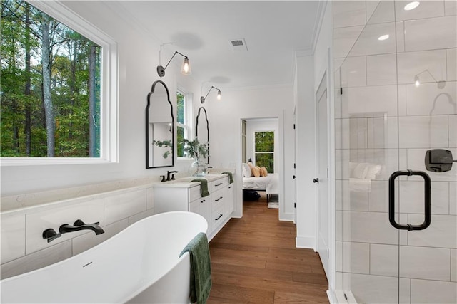 bathroom with hardwood / wood-style floors, vanity, plus walk in shower, and crown molding