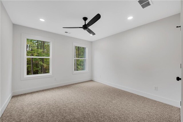 spare room featuring ceiling fan and carpet