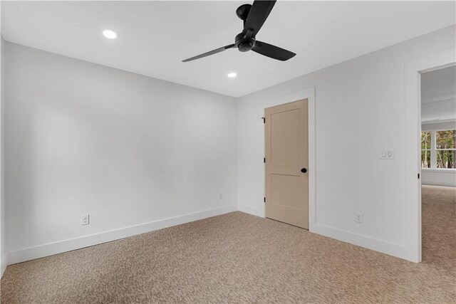 carpeted spare room with ceiling fan