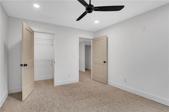 unfurnished bedroom featuring a closet, light colored carpet, and ceiling fan