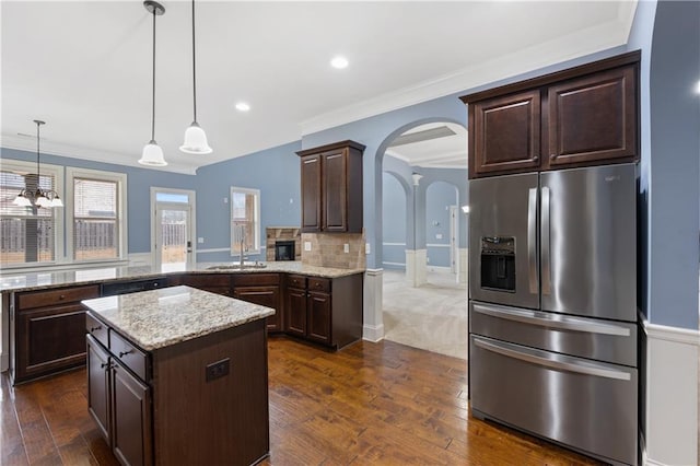 kitchen featuring dark wood finished floors, stainless steel fridge with ice dispenser, arched walkways, ornamental molding, and dark brown cabinetry