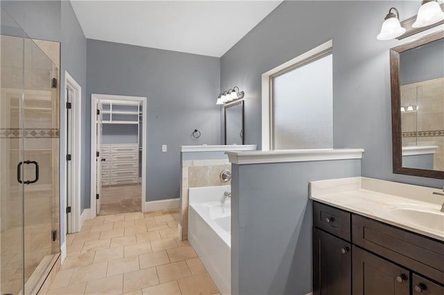 full bathroom featuring a spacious closet, baseboards, a garden tub, a stall shower, and vanity