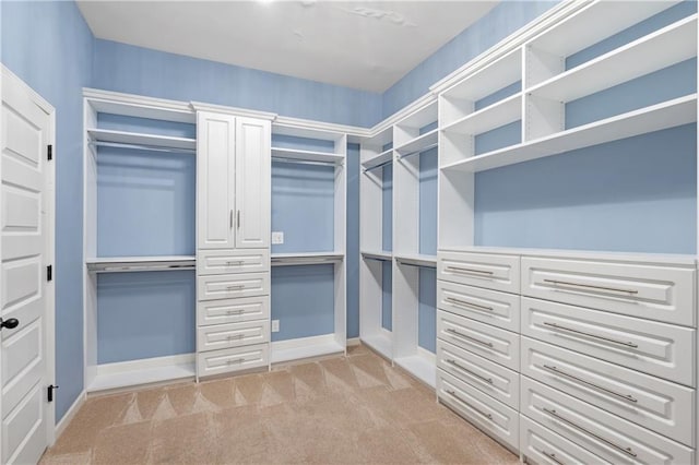 walk in closet featuring light colored carpet