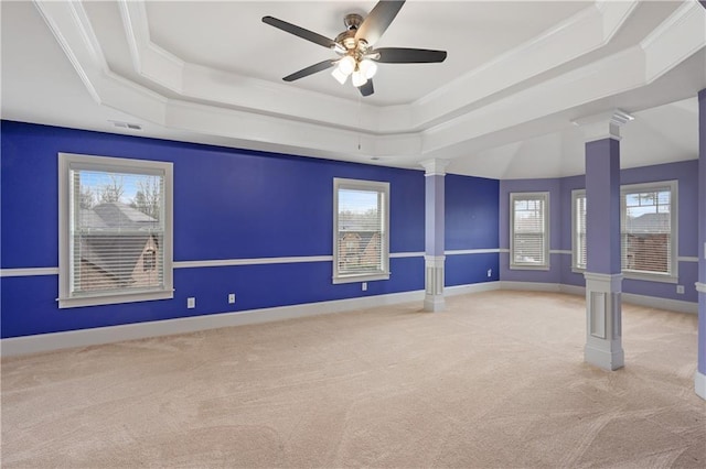 unfurnished room with carpet, visible vents, baseboards, a tray ceiling, and decorative columns