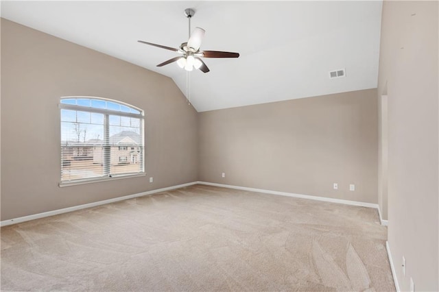 empty room with visible vents, carpet flooring, baseboards, ceiling fan, and vaulted ceiling