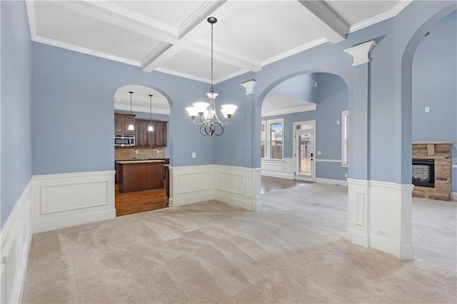 unfurnished dining area with light carpet, coffered ceiling, beam ceiling, and a fireplace