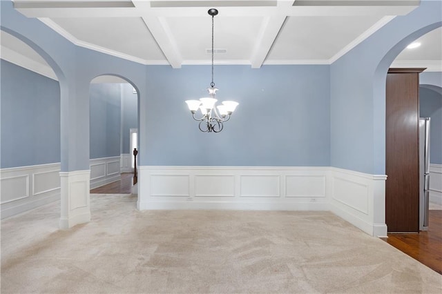 empty room featuring beamed ceiling, carpet flooring, visible vents, and coffered ceiling