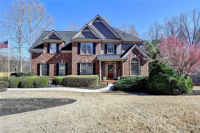 view of front of property with brick siding and a standing seam roof