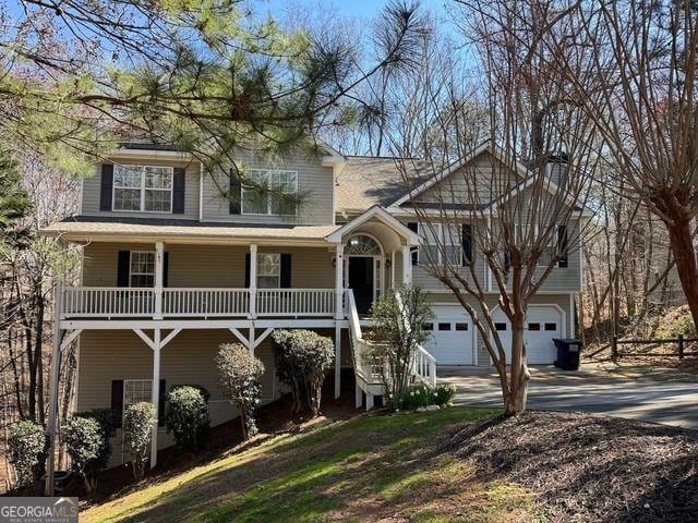 view of front of home with a porch, an attached garage, concrete driveway, and a chimney