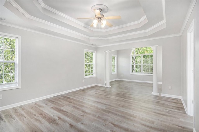 unfurnished room with crown molding, a ceiling fan, a raised ceiling, and wood finished floors