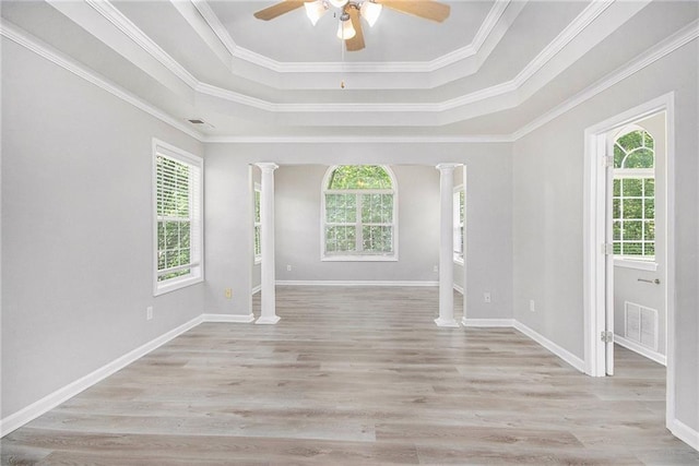 spare room with ornate columns, ceiling fan, a tray ceiling, and visible vents