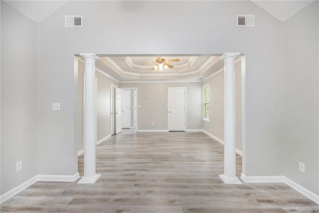 entryway with crown molding, a raised ceiling, a ceiling fan, and visible vents