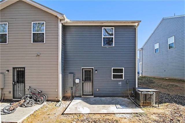 back of property with a patio and central AC