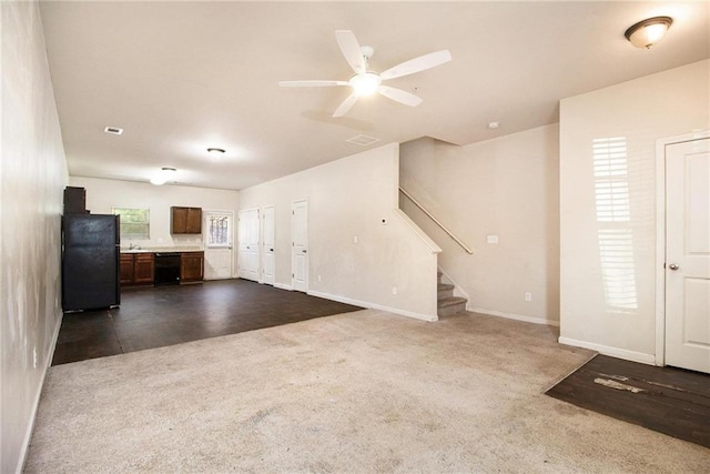 unfurnished living room featuring ceiling fan, sink, and dark carpet