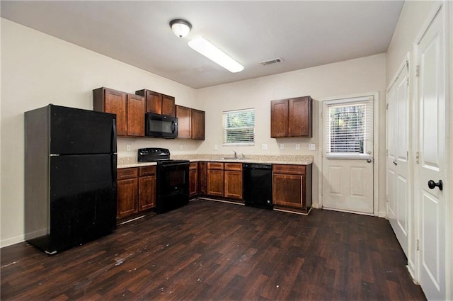 kitchen with black appliances, dark hardwood / wood-style floors, and sink