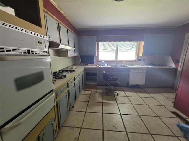 1437 Troupe St, Augusta, GA 30904 - kitchen with white appliances, under cabinet range hood, a warming drawer, light countertops, and light tile patterned floors