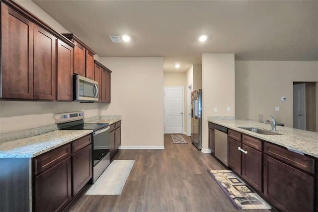 157 Oliver Dr, Locust Grove, GA 30248 - kitchen featuring light stone countertops, baseboards, dark wood-type flooring, a sink, and appliances with stainless steel finishes